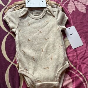 Nike Infant Bodysuit in Beige with Swoosh Pattern